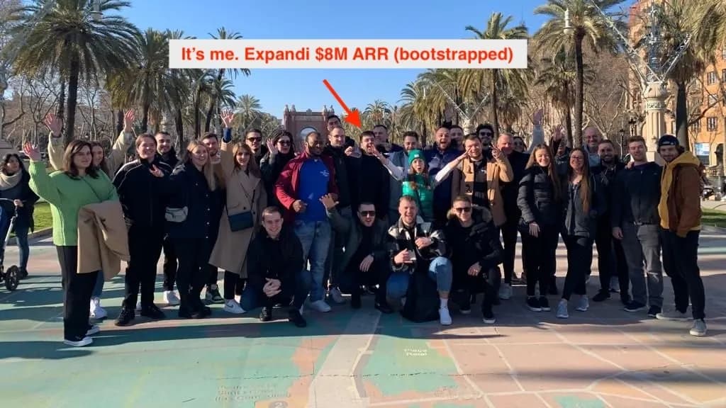 Group photo of the Expandi team in a park, with an arrow pointing at Ilya and the caption Expandi $8M ARR bootstrapped